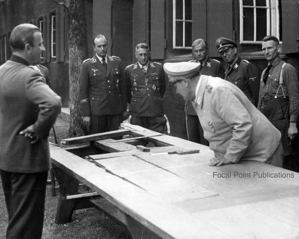 Hermann Göring inspects the table damaged by the traitors' bomb
